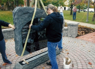 Tim Milligan, Owner of Milligan Memorials guiding the stone into place. October 18, 2013.
